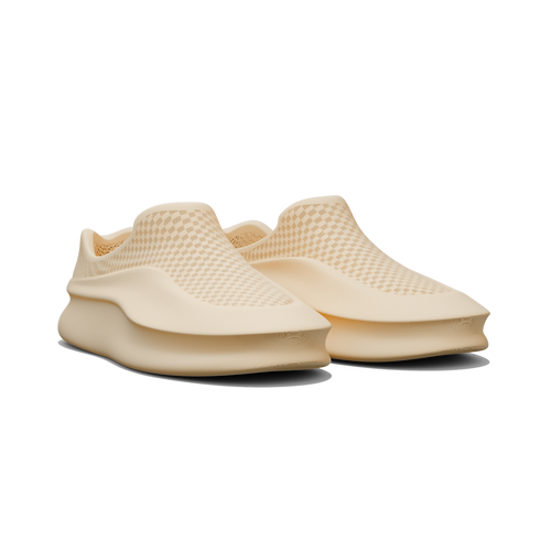 Pair of beige slip-on shoes on a white background